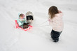 Photo: a big sister pulling her little sister in a sled a big sister pulling her little sister in a sled