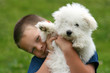 Happy boy bearing a puppy in his arms
