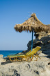 Rocky beach, sun bed and palm umbrella Rocky beach, sun bed and palm umbrella