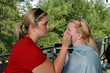A makeup artist applying eyeliner to a model
