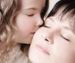 Child kissing her mother Child kissing her mother