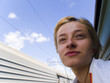 girl with ear looks from the train windows