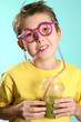 Boy drinks a healthy juice with wheatgrass, barleygrass and 