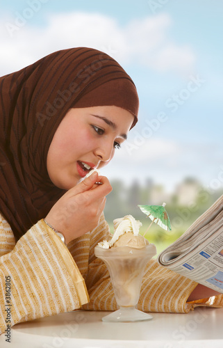 Photo: Young veiled woman reading a newspaper Young veiled woman reading a newspaper