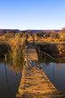 Rope bridge leading across a river to a small island.