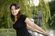 Smiling latin brunette girl in a black blouse outdoor portrait