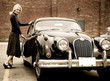 A beautiful blond woman getting into a classic car