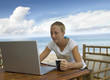 Photo: attractive young woman checks email while on holiday attractive young woman checks email while on holiday