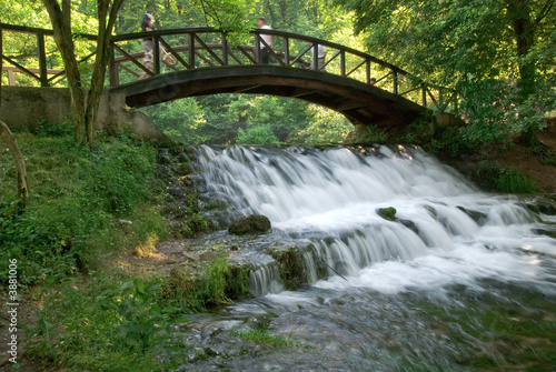 wooden bring over small waterfall
