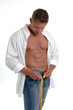 A bodybuilder in an open shirt measuring his waist