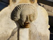 Fontaine, tête de femme sculptée, eau coulant par sa bouche