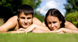 Happy ouple lying on grass.