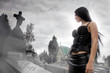 Long black haired woman in a misty cemetery