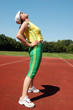 Active senior woman stretching in a stadium