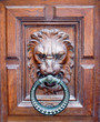 Une porte avec un lyon qui tient dans sa gueule un anneau