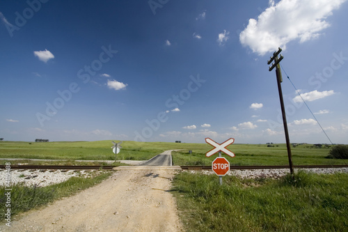 Photo: Empty path through Railway lines with stop sign Empty path through Railway lines with stop sign
