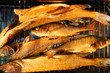Fresh smoked pike and pearch fishes on smoking grill