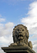 Lion statue waits below blue sky and clouds Lion statue waits below blue sky and clouds
