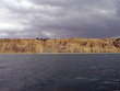 Sandstone cliffs cleave dark skies and ocean Sandstone cliffs cleave dark skies and ocean