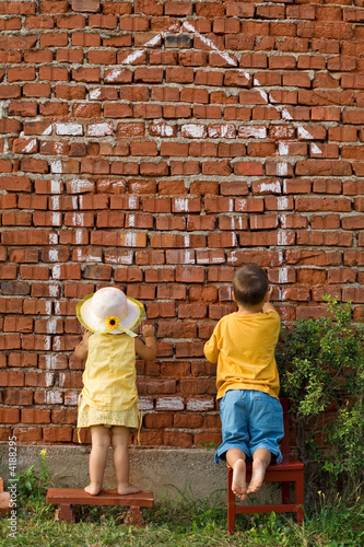 Foto: Two kids drawing a home Two kids drawing a home