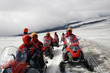 people on snowmobiles on glacier