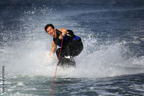 sliding wakeboarder with strained face and closed eyes in water sliding wakeboarder with strained face and closed eyes in water