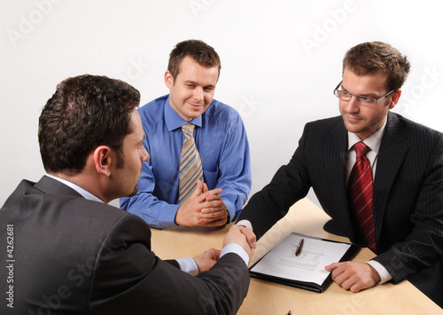 Photo: handshake over signed cotract handshake over signed cotract