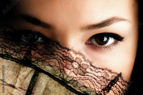 female eyes behind fan