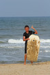 Foto: Boy exits ocean with boogie board Boy exits ocean with boogie board