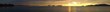 A ultra wide panorama view of a golden sunset ocean