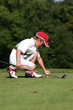 petit golfeur plante un tee