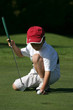 petit golfeur place sa balle