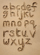 The alphabet written in sand on a beach.