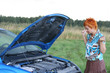 young red-haired woman with her broken car.