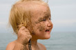 baby with sand on cheeks