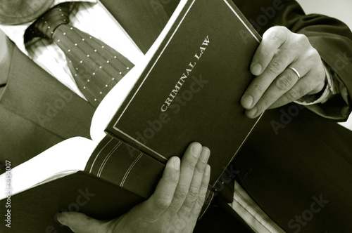 Photo: lawyer holding criminal law book lawyer holding criminal law book