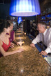 two females talk to a bartender