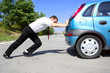 Photo: Businessman pushing a car Businessman pushing a car