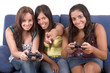 Three young smiling women playing videogames