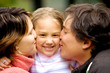 parents kissing daughter