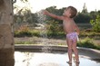 child playing with water stream
