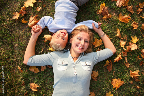 Photo: mother and son lied on autumn meadow mother and son lied on autumn meadow
