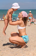 mother holds daughter on the beach