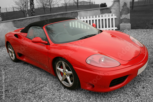 Fototapeta Bright red convertible sports car on a black and white backgroun