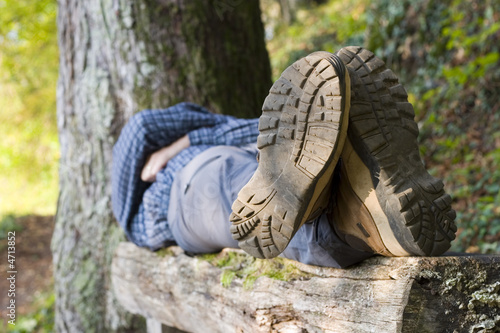 Photo: Hiker lying on a wooden bench Hiker lying on a wooden bench