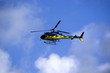 Yellow-blue Helicoper in the sky. Side view