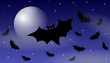Halloween bats flying under the moon