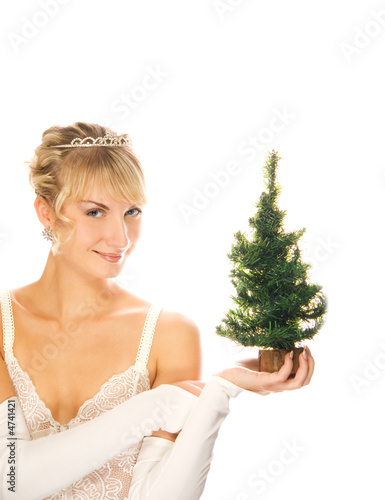 Photo: Beautiful blond girl holding a Christmas tree isolated on white Beautiful blond girl holding a Christmas tree isolated on white