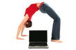 Young woman performing yoga in front of a laptop