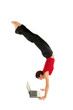 Woman doing handstand and using laptop 